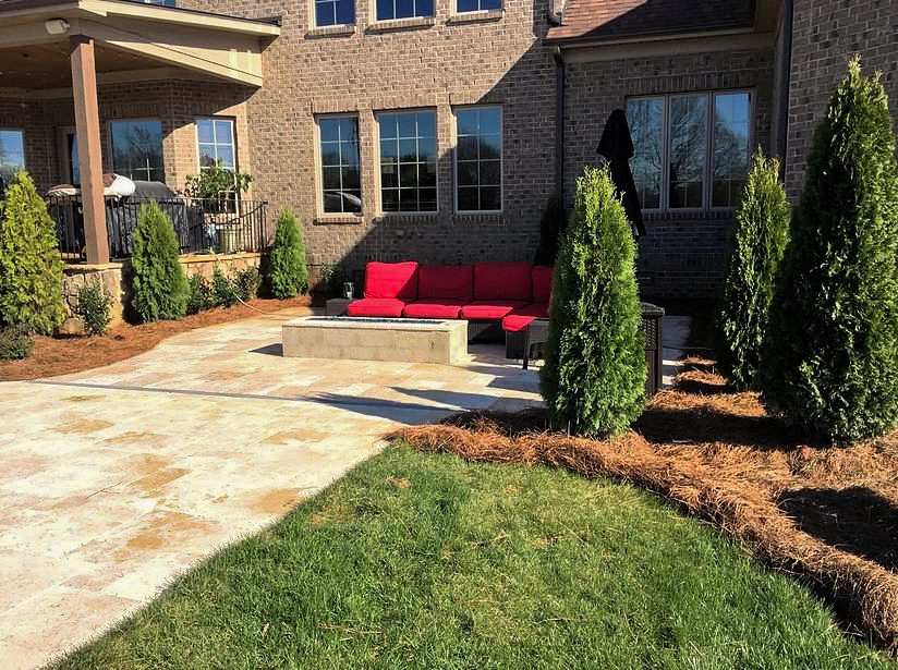 A patio with a couch and fire pit in the middle of it.