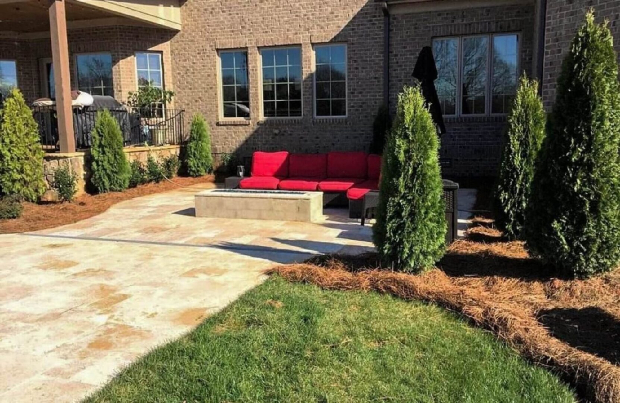 Red couch and fire pit on patio.