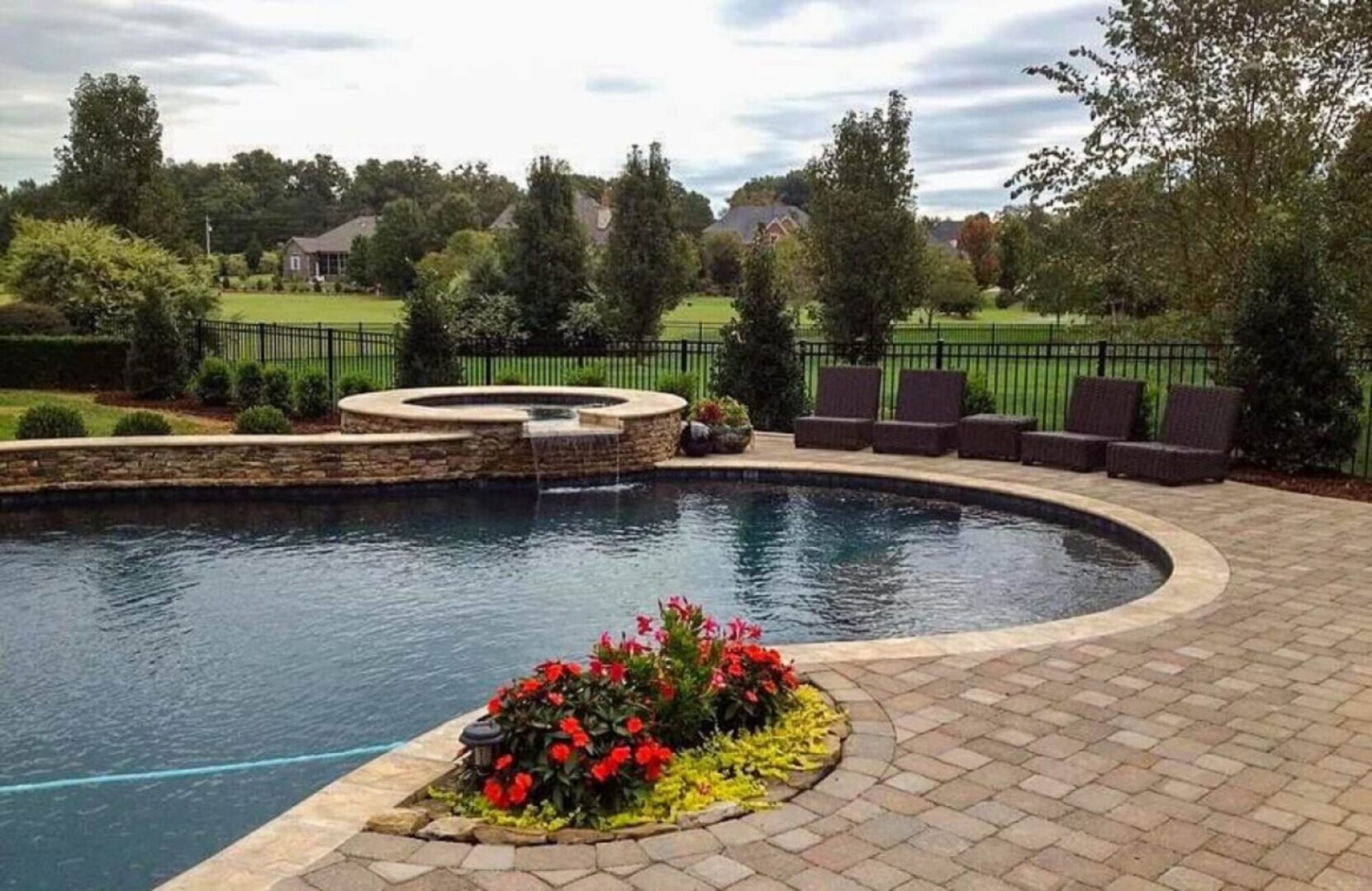 A pool with flowers in the center of it.